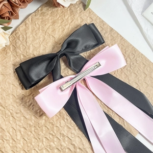 Elegant long ribbon bow hair clips in pink and black satin fabric with metal clips