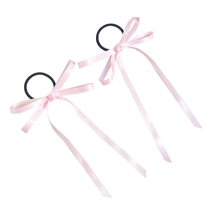 Pair of ballet style pink satin ribbon bow hair ties with long streamers on white background