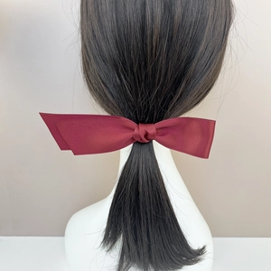 Detailansicht einer weinroten Satin-Schleife Haarspange mit elegantem Seidenglanz am Modell
