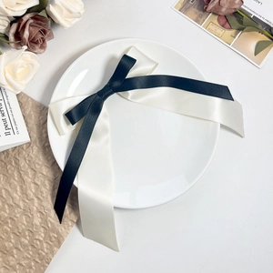 Détail d'un élégant nœud en ruban satin noir et blanc sur un plateau décoratif