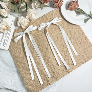 Elegant set of two white satin ribbon bow hair clips with long tails on a floral background