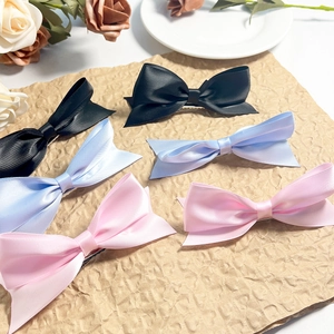 Tre fermagli per capelli in raso nero blu e rosa su carta vintage con fiori freschi