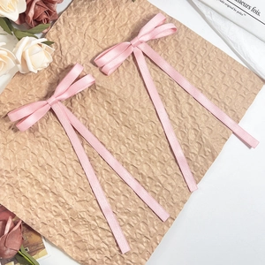 Set of two soft pink satin ribbon bow hair clips with long streamers in a romantic style