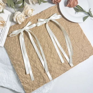 Detail view of two white satin ribbon bow hair clips on vintage paper with floral accents