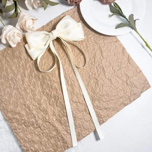 Détail d'un nœud de cheveux élégant en satin crème avec de longs rubans sur papier