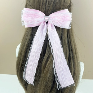 Detailed back view of a pink lace bow hair clip with a heart diamond on long straight hair