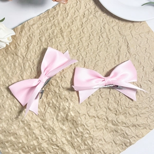 Coppia di dolci fermagli per capelli con fiocco in raso rosa su carta vintage e rose