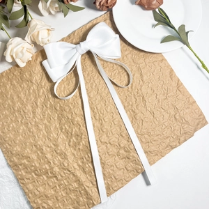 Détail d'un grand nœud à cheveux en satin blanc avec de longs rubans sur papier