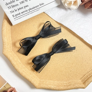 Détail de deux barrettes nœuds noirs de style ballet avec tissus satin et mesh