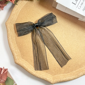 Detail einer eleganten schwarzen Haarklammer mit Netzschleife und langen Bändern