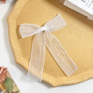 Detailansicht einer weißen Organza-Schleifen-Haarspange mit eleganten langen Bändern