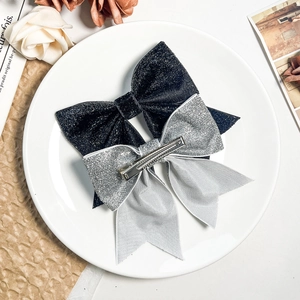 Elegant glittering bow hair clips in black and silver colors with shiny sequin texture