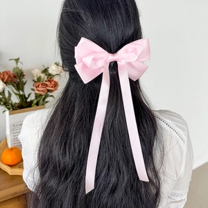 Rosa Satin Schleife Haarspange mit langen Bändern getragen in einer süßen Frisur