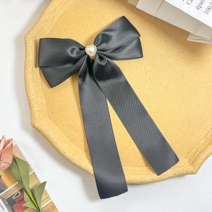 Barrette nœud en satin noir avec perle en forme de cœur et bordure dorée élégante