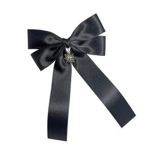 Elegant black satin ribbon hair bow featuring a vintage silver sun pendant charm