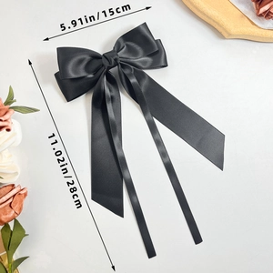 Detailed view of black satin bow hairclip with dimensions 15cm width and 28cm length
