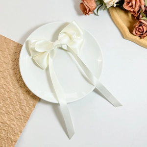 Detail einer eleganten creme-satinierten Schleifen-Haarspange mit langen Bändern