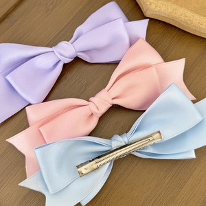 Three elegant satin double bow hair clips in pastel purple, pink, and light blue colors