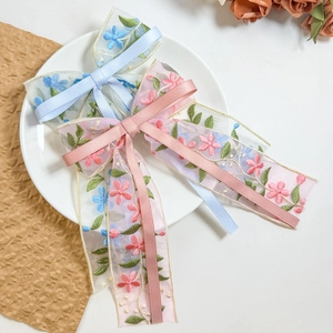 Floral embroidered tulle bow hair clip with long ribbons in soft pink and blue pastel colors