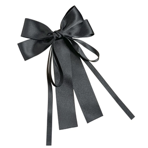 Elegante fermaglio per capelli in raso nero con nastri lunghi su sfondo bianco
