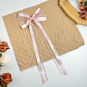 Detail der rosa Satin- und Organzaschleife mit langen Bändern auf Vintage-Hintergrund
