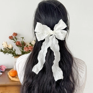 Elegante fermaglio per capelli con fiocco bianco in tessuto jacquard su modella