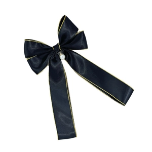 Barrette nœud en satin noir élégante avec surpiqûres dorées et pendentif perle sur fond blanc