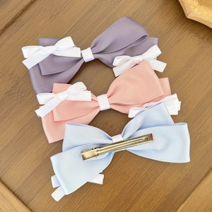 Three-piece satin bow hair clips set in lavender, pink, and blue with white accents