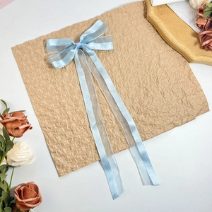 Details von hellblauen Haarschleifen mit langen Bändern auf Vintage-Papier und Rosen