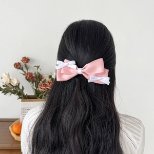 Rear view of French pink satin bow hair clip on long hair with elegant Korean aesthetic