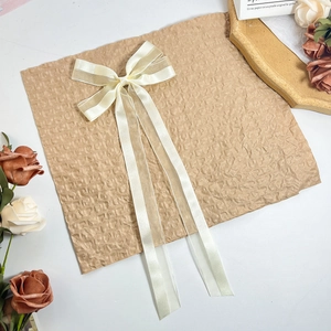 Detail einer eleganten elfenbeinfarbenen Haarschleife aus Satin und Organza mit Band