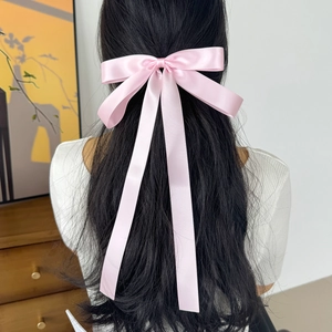Elegant pink satin bow hair clip with long ribbons for a sweet and stylish hairstyle