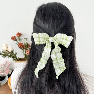 Sweet green plaid bow hair clip for women featuring textured seersucker fabric on long hair