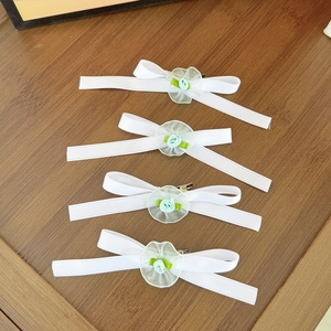 Set di fermagli per capelli con fiocchi bianchi e fiori in tessuto su legno scuro