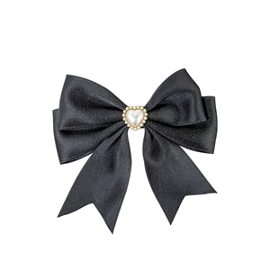 Elegant black satin bow hair clip featuring a heart shaped pearl with micro-pave detailing