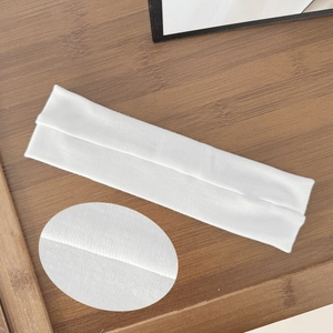 Minimalist white elastic sports headband with soft knit texture on a wooden background