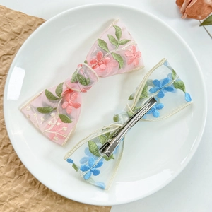 Dettaglio di fermagli per capelli con fiori in pizzo ricamato su un piatto ceramico