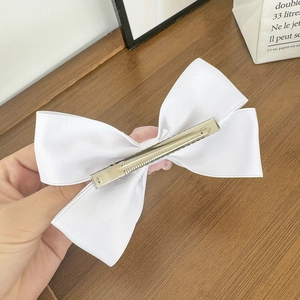 Elegante fermaglio per capelli in raso bianco con doppio fiocco e clip in metallo su legno