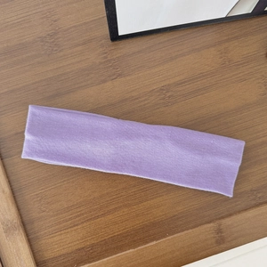 Detailed view of purple elastic yoga headband with knit texture on wood background