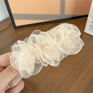 Détail de la barrette à trois camélias en organza crème avec des pétales superposés