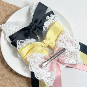 Three-piece lace bow hair clips in black, yellow, and pink with metal duckbill clips