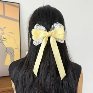 Lace bow hair clip with long yellow satin ribbon streamers for elegant women's hairstyles