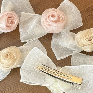 Elegante Haarspangen mit Netzschleife und Rosen in Rosa und Champagner auf Holzdekor