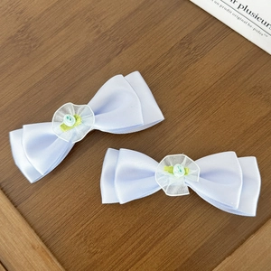 Détail de barrettes à cheveux en satin bleu clair avec dentelle et roses en tissu