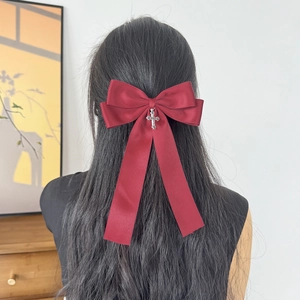 Elegant large burgundy satin bow hair clip with silver vintage cross on black hair