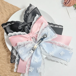 Vintage French lace bow hair clips in black, pink and blue set on a decorative plate