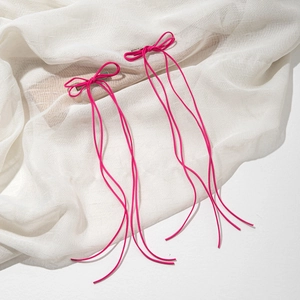 Lot de deux barrettes nœuds rose fuchsia avec longs rubans sur tissu blanc texturé