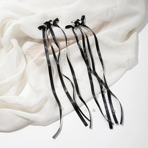 Detail of sweet black silk bow hair clips with heart crystals and cascading ribbon tassels