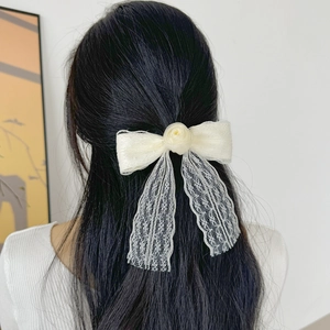 Elegant cream lace bow hair clip with rose decoration and long fringe on model