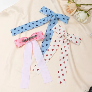 Trois pinces à cheveux à nœud avec motifs de cœurs en bleu, rose et blanc satiné